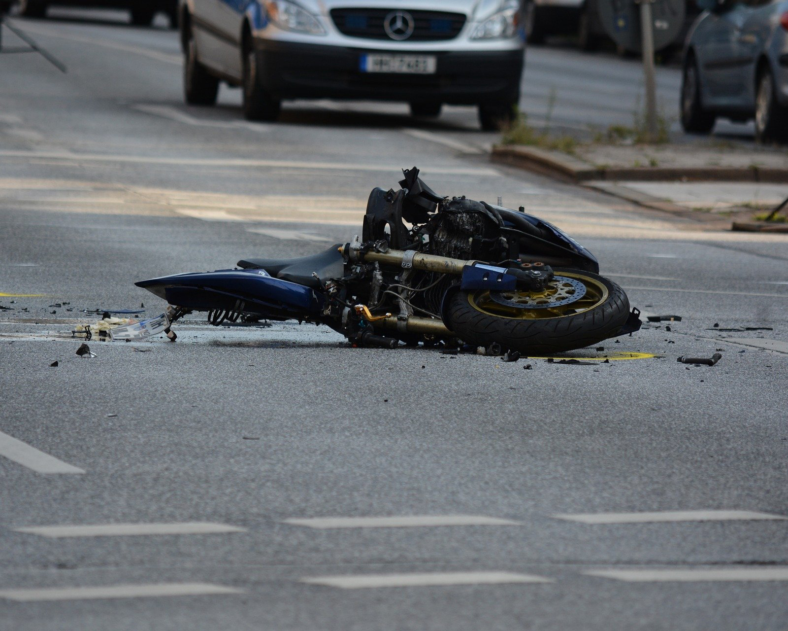 Crashed motocycle laying on the ground in the middle of the road - Spitzer Legal Motorcycle Accident Practice Area