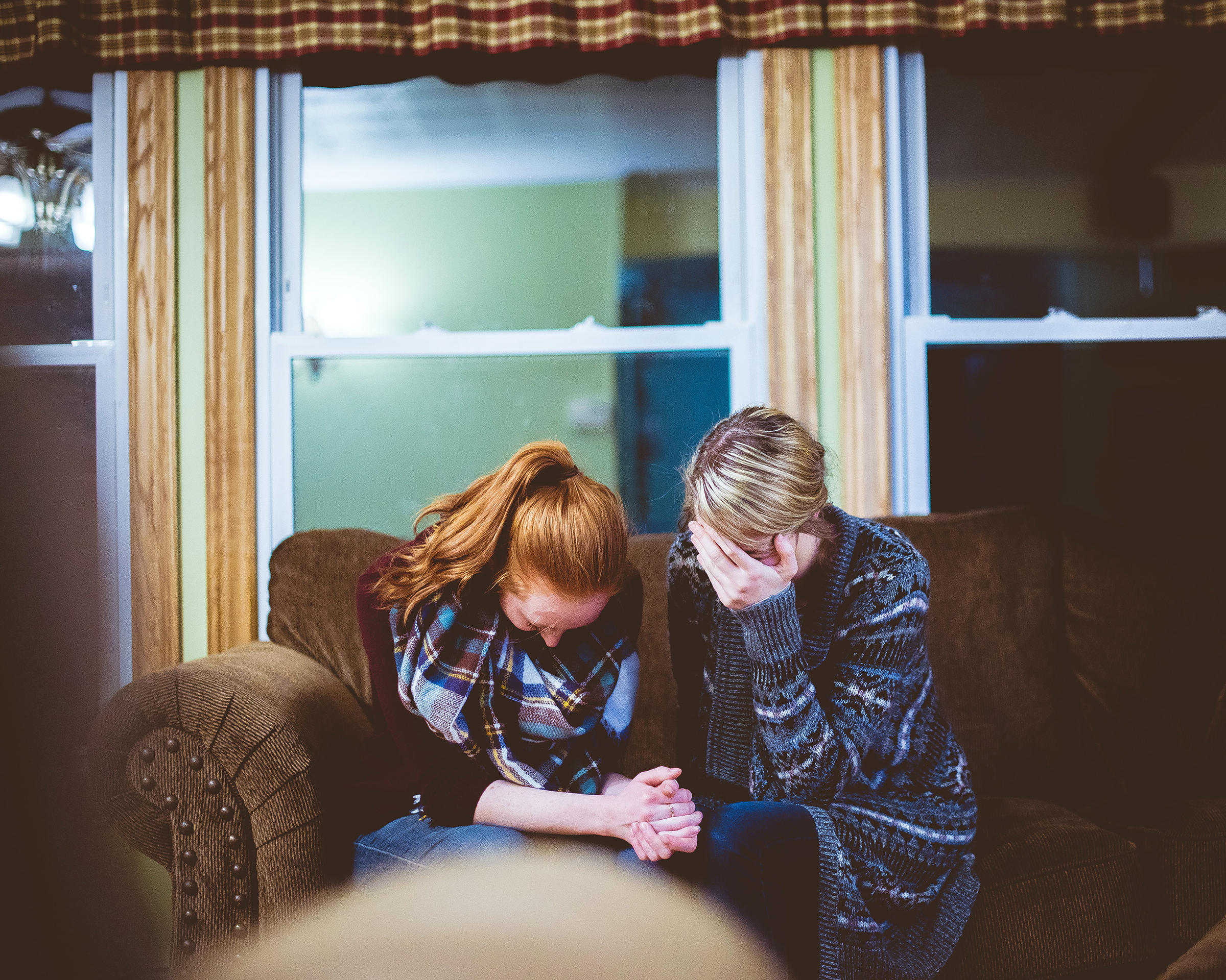 Mother and daughter crying on a couch in their living room - Spitzer Legal Wrongful Death Practice Area